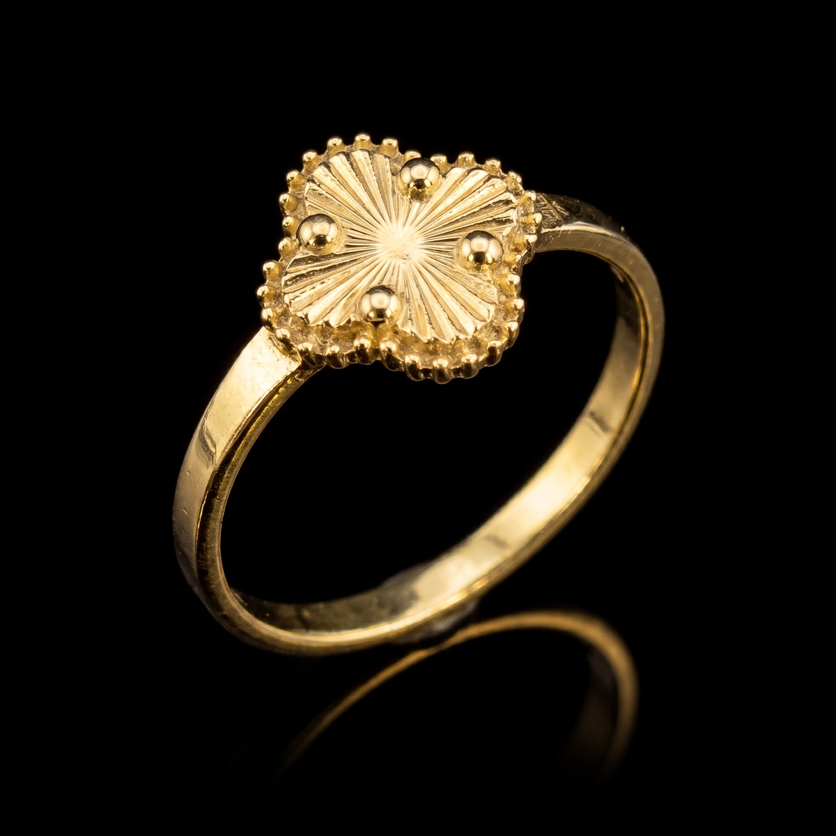 10k gold clover ring at a 45-degree angle on black